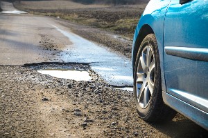 car driving over pothole