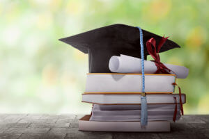 graduation cap on books