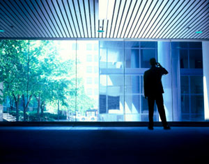 silhouette of a man on a phone call, who may be blowing the whistle on his employer for deception or wrongdoing
