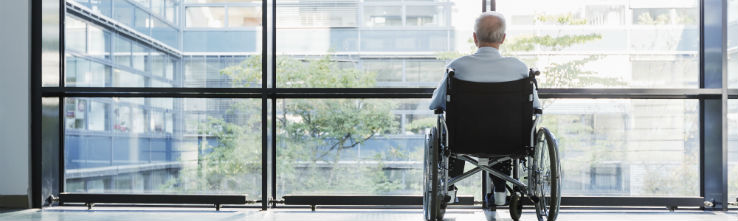 senior in wheelchair looking out window