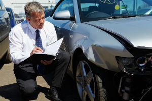 insurance adjuster examining car accident