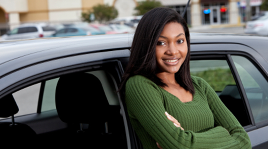 teen driver leaning on the car