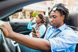 man texting while driving with a passenger