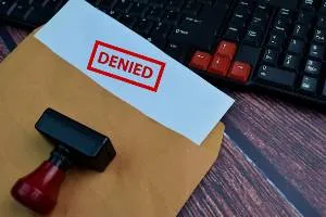 red denied stamp on paper in envelope